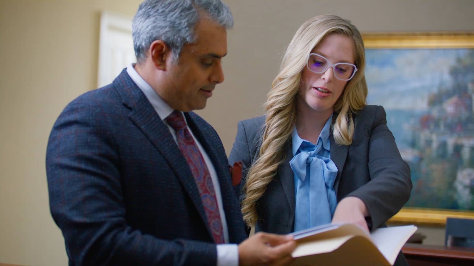 Young business professional smiling at their phone.